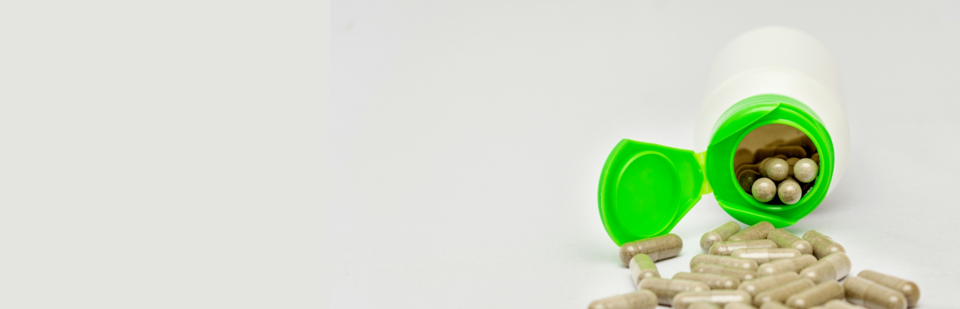 green pill bottle pouring medicine on the counter 