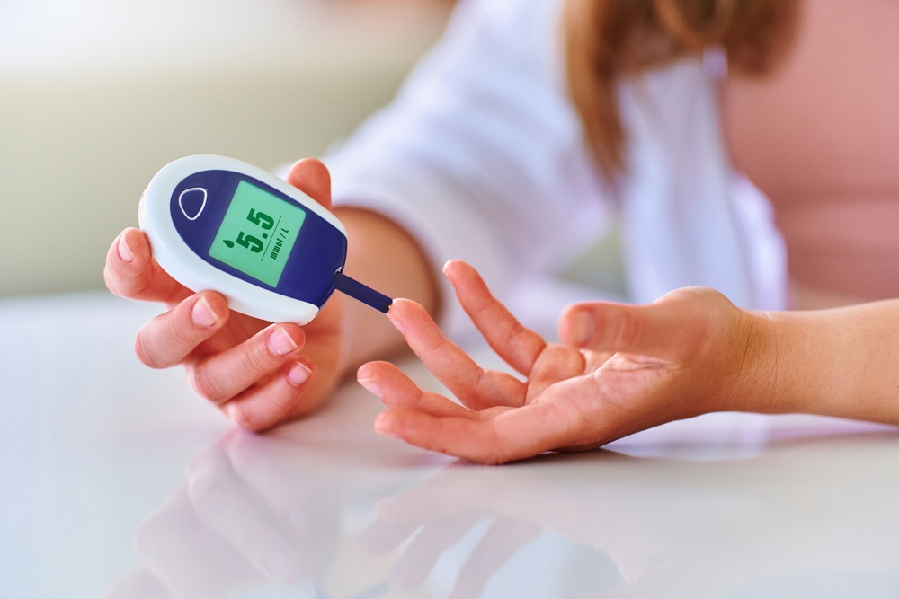 woman using glucose meter to test glucose levels