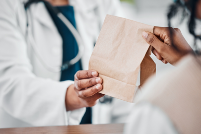 pharmacist giving patient bag of medications